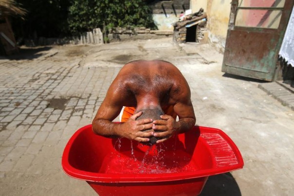 A Roma man cools himself in the impoverished outskirts of Ozd, northeastern Hungary, in the grip of a heat wave, A Roma man cools himself in the impoverished outskirts of Ozd, northeastern Hungary, in the grip of a heat wave,