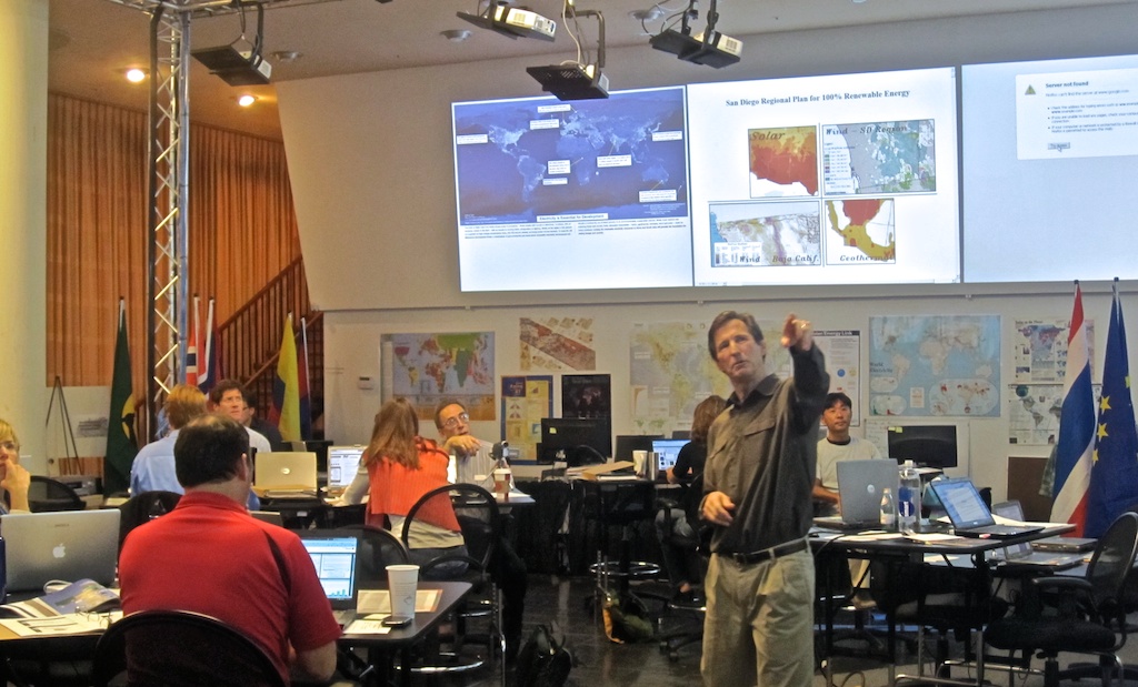 Peter drawing attention an image on one of the 12 screens.